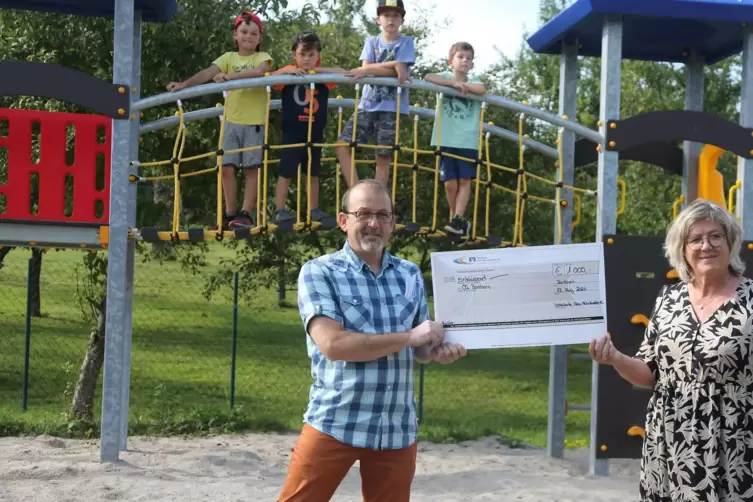 Ortsbürgermeister Uwe Bier nimmt den symbolischen Scheck für eine 1000-Euro-Spende von Volksbank-Vorstandsmitglied Sabine Mack e