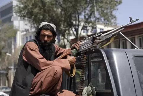 Die Taliban sind in Afghanistan wieder an der Macht: Ein Kämpfer sitzt auf dem Rücksitz eines Fahrzeugs mit einem Maschinengeweh