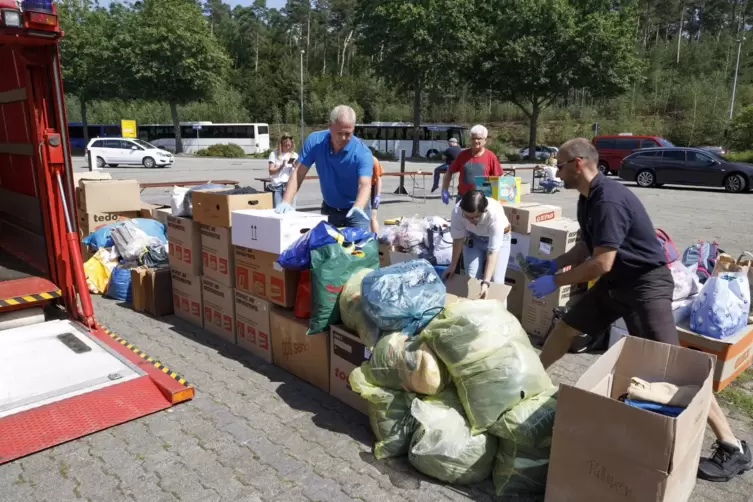 Ralf Hechler (blaues T-Shirt) legt Hand an und dirigiert die freiwilligen Helfer beim Packen der gespendeten Hilfsgüter. 