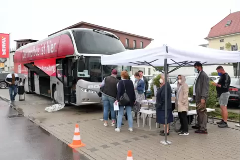 Warten auf die Impfung: Bürger am Donnerstagvormittag auf einem Supermarkt-Parkplatz in Dudenhofen. 