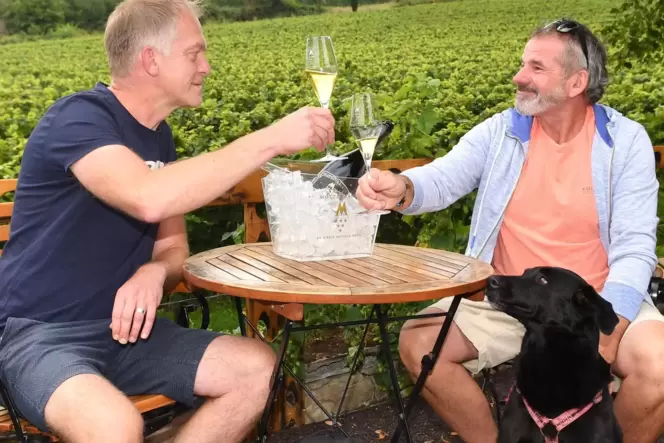 Volker und Detlef Köhler mit Hund Cira auf der Terrasse des Sektguts Menger-Krug in Deidesheim.