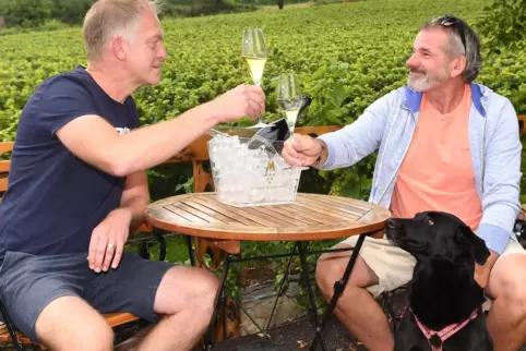 Volker und Detlef Köhler mit Hund Cira auf der Terrasse des Sektguts Menger-Krug in Deidesheim.