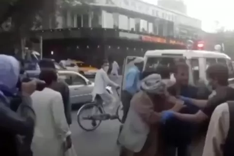 In diesem Bild aus einem Video kümmern sich Menschen um eine verwundete Person in der Nähe des Ortes einer tödlichen Explosion a