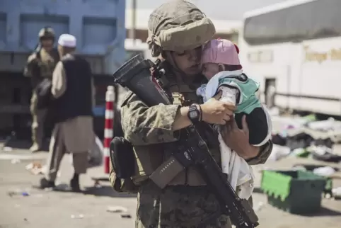 Eine US-Soldatin trägt ein afghanisches Baby am Flughafen in Kabul.