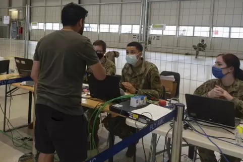Ein aus Afghanistan geretteter Man spricht auf der Air Base mit US-Soldaten.