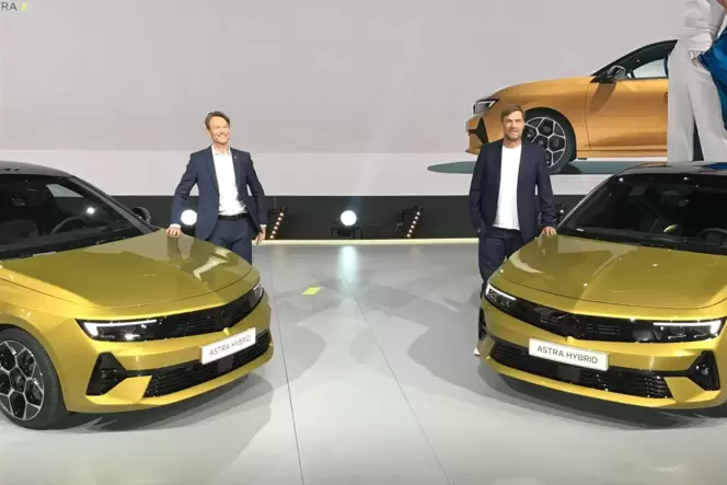 Opel-Chef Uwe Hochgeschurtz (links) und Markenbotschafter Jürgen Klopp neben zwei neuen Astras.