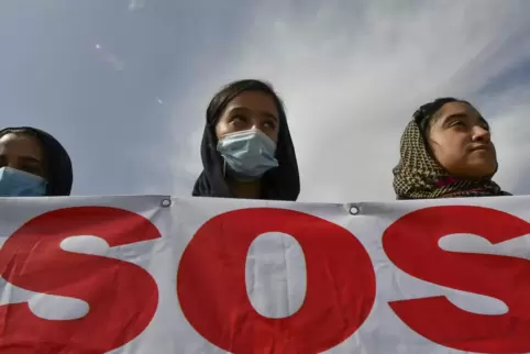 Afghanische Migrantinnen halten bei einer Kundgebung vor der US-Botschaft in Kirgistan ein Banner mit der Aufschrift „SOS“. Die 