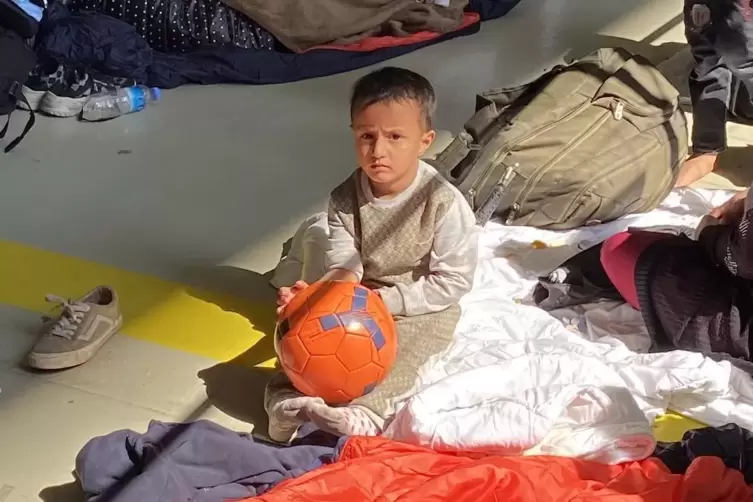 Dieses Fl&uuml;chtlingskind in Hangar 5 hat einen Ball geschenkt bekommen.