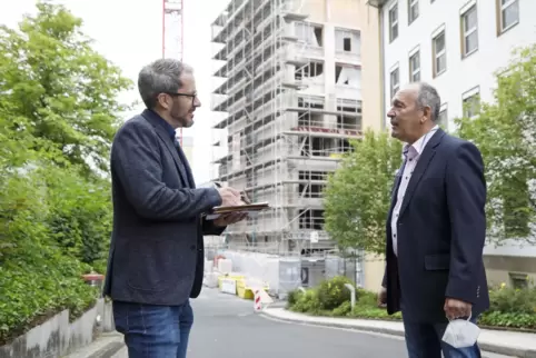 Geschäftsführer Peter Förster erklärt Redakteur Christian Clemens wie die Arbeiten an Haus 8 (Hintergrund) vorangehen. 