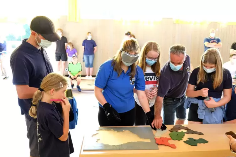 Laura aus der Breitfurter Jugendfeuerwehr puzzelt das Saarland blind zusammen.