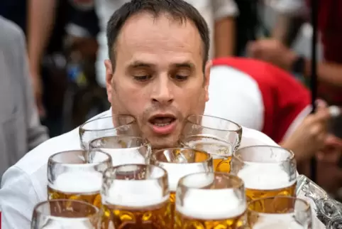 Maßnahme: Oliver Strümpfel hält mit 29 Bierkrügen den Weltrekord im Maßkrugtragen (hier 2017 auf dem Volksfest Gillamoos in Aben