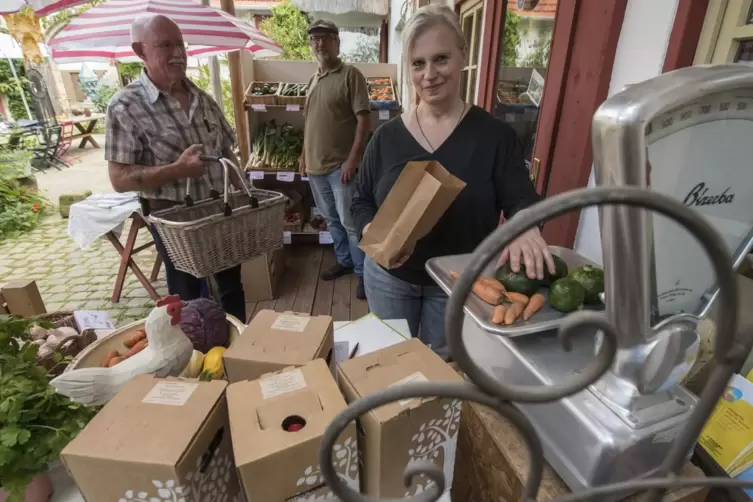 Susanne Erdmann verkauft Ortsbürgermeister Willi Mühlberger frisches Gemüse. Gemeinsam mit Thomas Erdmann (hinten) betreibt sie 