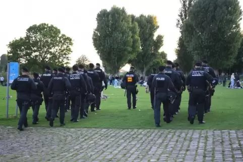 Pfingsten 2021: Nach Ausschreitungen auf der Heidelberger Neckarwiese räumen Polizisten das Gelände.