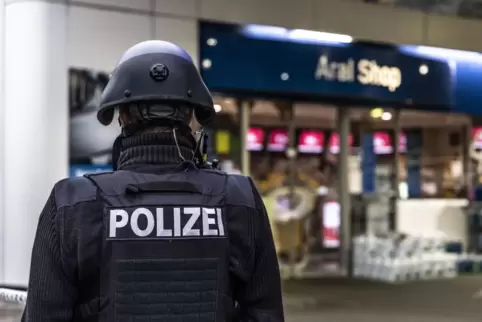 Ein Polizist sichert den Bereich vor der Tankstelle in Idar-Oberstein. 