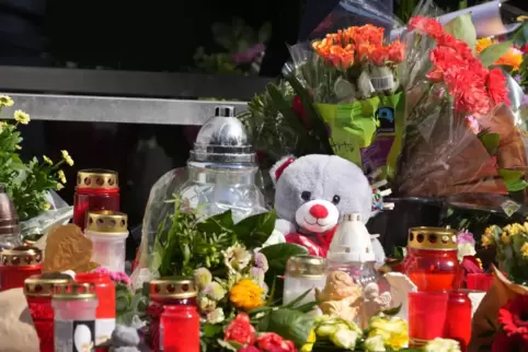 Blumen, Kerzen und Botschaften an das Opfer liegen an einer Tankstelle in der Innenstadt von Idar-Oberstein.