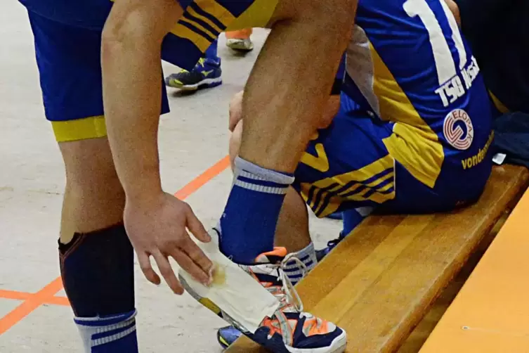 Die Handballer schmieren sich Harz auf den mit Klebestreifen präparierten Schuh, damit sie das Klebemittel immer im Spiel parat 