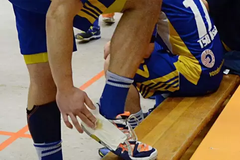Die Handballer schmieren sich Harz auf den mit Klebestreifen präparierten Schuh, damit sie das Klebemittel immer im Spiel parat 