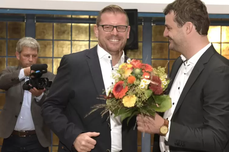 Blumen für den Sieger: von SPD-Parteichef David Guthier für Christian Schreider (links).