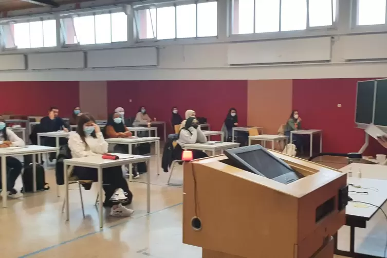 Mathematik-Vorlesung im Audimax: Etwa 40 Studierende sind in Präsenz dabei, während Professor Ludwig Peetz die Gaußsche Summenfo