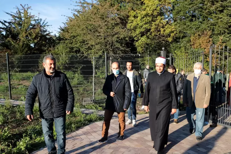 Imam Mecit Bilen betritt mit weiteren Muslimen und Verantwortlichen das neue Gräberfeld. 