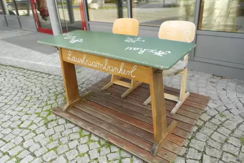 Das Lausbuambankerl steht vor der Grundschule in Asching.