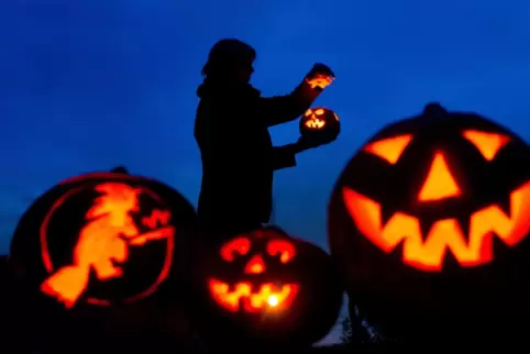 Leuchtende Kürbis-Gesichter gehören zu Halloween.