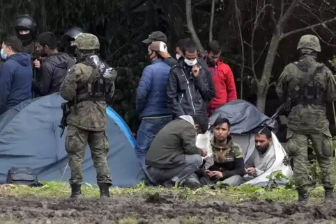  Nahe dem polnischen Weiler Usnarz Gorny umringen bewaffnete Sicherheitskräfte im September eine Gruppe von Migranten, die von B