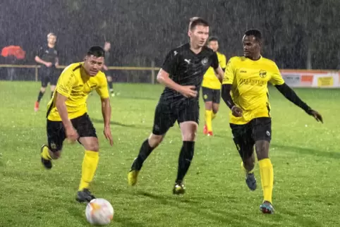  Fadil Dumishaj, der Schwanheimer Niklas Kempf und Abdikarim Hassan (von links) im Regen in Schwanheim.