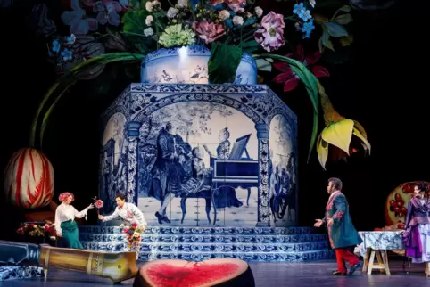 Die Sänger agieren in einem monströsen Stillleben von barocker Opulenz vor einer Fayence-Blumenvase. 