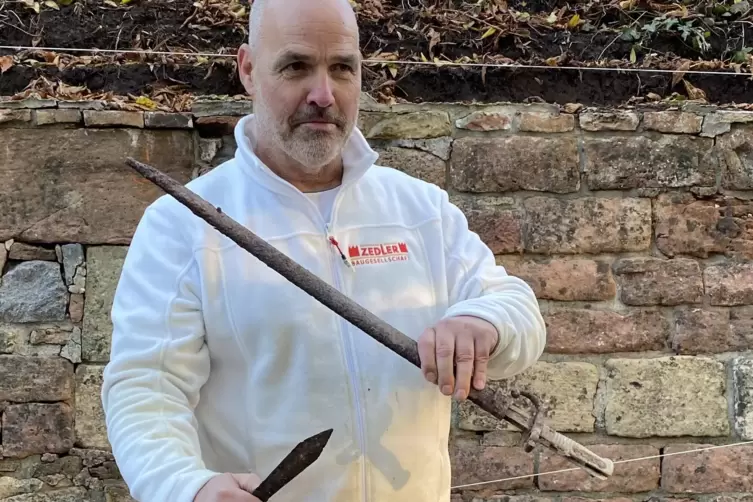 Polier Norbert Kolm mit den gefunden Waffen. 