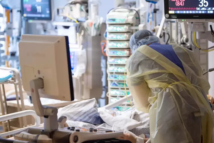 Ein Intensivpfleger arbeitet auf einer Intensivstation an einem Covid-19-Patient. 
