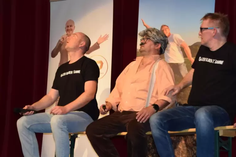 Christian Chini, Oliver Betzer und Jürgen Nagel stehen gemeinsam für den guten Zweck auf der Bühne, während im Saal kein Auge tr
