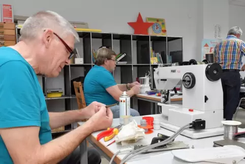 Wolfgang Eller (links) bei der Reparatur einer Nähmaschine. 