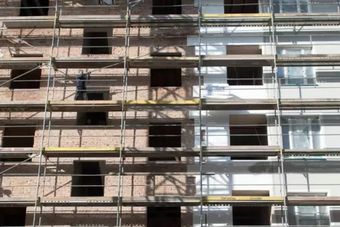 Die Fassade eines Altbau-Mehrfamilienhauses wird mit einer Wärmedämmung verkleidet. 