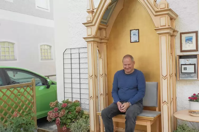 Tourismuschef Reiter sitzt auf einer Themenbank wie der Herr Pfarrer in der Sakristei. 