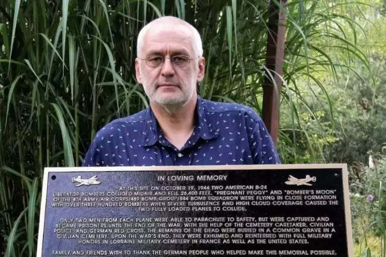 Vermisstenforscher Uwe Benkel mit der von Tom und Mary Burton gestifteten Bronzetafel.