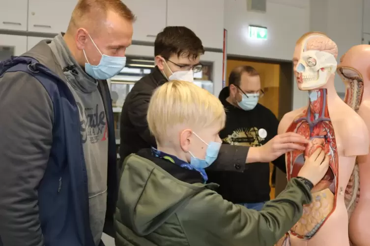 Der neunjährige Lars und sein Vater Stefan Römmig bekommen von Schüler Niklas und Lehrer Sebastian Göttges Infos über den mensch