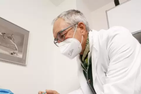 Arzt Ulrich Frankenberger impft gerade einen Patienten.
