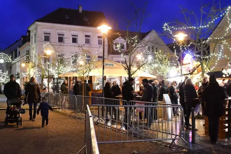 Hinterm Zaun: Weihnachtsmarkt- Betrieb auf dem Ludwigsplatz. 