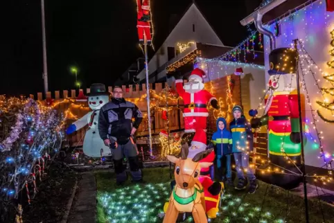  Stefan Scharffenberger (links) in seinem Lichtergarten. Die beiden Nachbarskinder Armin und Bruno freuen sich an der Weihnachts