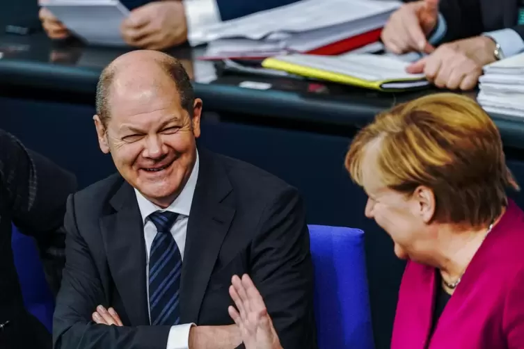 Können gemeinsam lachen: Bald-Kanzler Olaf Scholz (SPD) und Noch-Kanzlerin Angela Merkel (CDU) 2019 im Bundestag. 