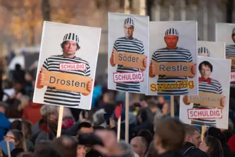Hier wird gegen Corona-Schutzmaßnahmen demonstriert: Protestierende einer „Querdenker“-Demonstration in Leipzig halten Schilder 