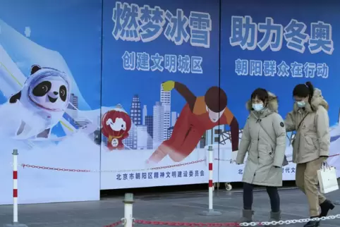 Chinesinnen gehen an der Werbung für die Olympischen Winterspiele im eigenen Land vorbei. 