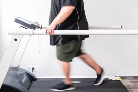Ein Mann trainiert auf einem Laufband, um seine Ausdauer nach einer Coronainfektion zu stärken. 
