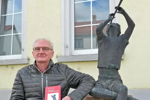 Der Autor und sein Buch: Reinhold Horländer vor dem Flötenspieler-Brunnen, der in seinem Roman eine Rolle spielt.
