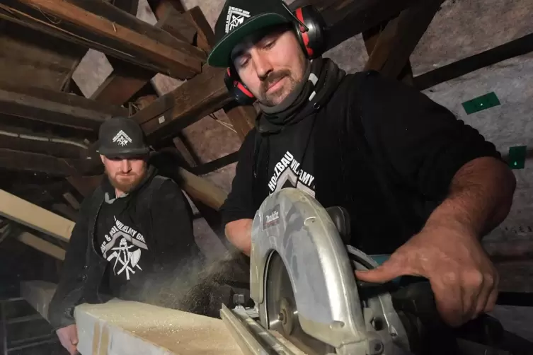 Florian Wilhelmy (rechts) und sein Kollege Nikolas Freitag haben viel zu tun. Auf einer Baustelle sägen sie die neue Schwelle fü