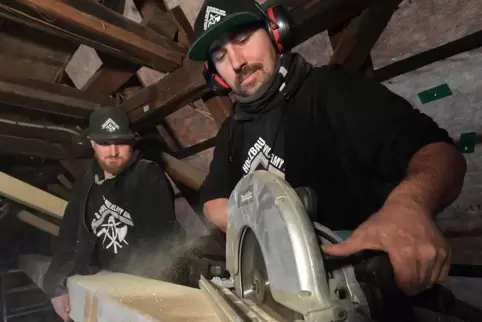 Florian Wilhelmy (rechts) und sein Kollege Nikolas Freitag haben viel zu tun. Auf einer Baustelle sägen sie die neue Schwelle fü