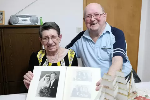 Renate und Berthold Meyer mit ihrem Hochzeitsbild von 1961 und einem Papiermodell der Gorch Fock. 