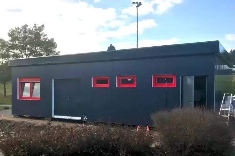 FCK-rote Fenster auf grauem Grund: die Fassade wird optisch angepasst an den Container auf der gegenüberliegendem Seite, in dem 