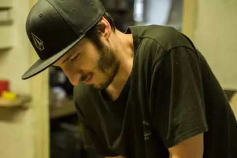 Jens Reuter in seiner Werkstatt beim Auseinandernehmen eines alten Skateboards.
